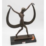 An Art Deco style bronzed figure of a semi nude female dancer in standing pose with outstretched