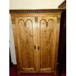 A French stained and reclaimed pine double door armoire, having floral carved detail and raised on