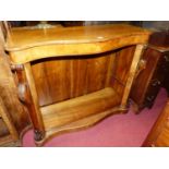 A mid-Victorian figured walnut serpentine front dwarf bookshelf, having pronounced carved corbels,