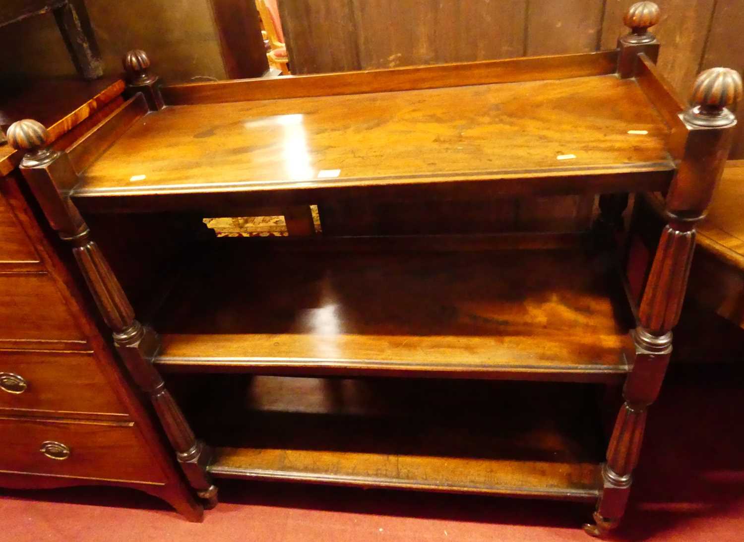 A Victorian mahogany three-tier buffet, having reeded finials over conforming supports, to