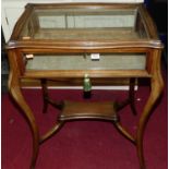 An early 20th century mahogany glazed hinge top bijouterie table, raised on slender cabriole