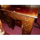 An Edwardian mahogany, satinwood inlaid and further crossbanded kneehole desk, having an arrangement