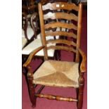 A country elm and rush seat ladder back open elbow chair, width 59cm