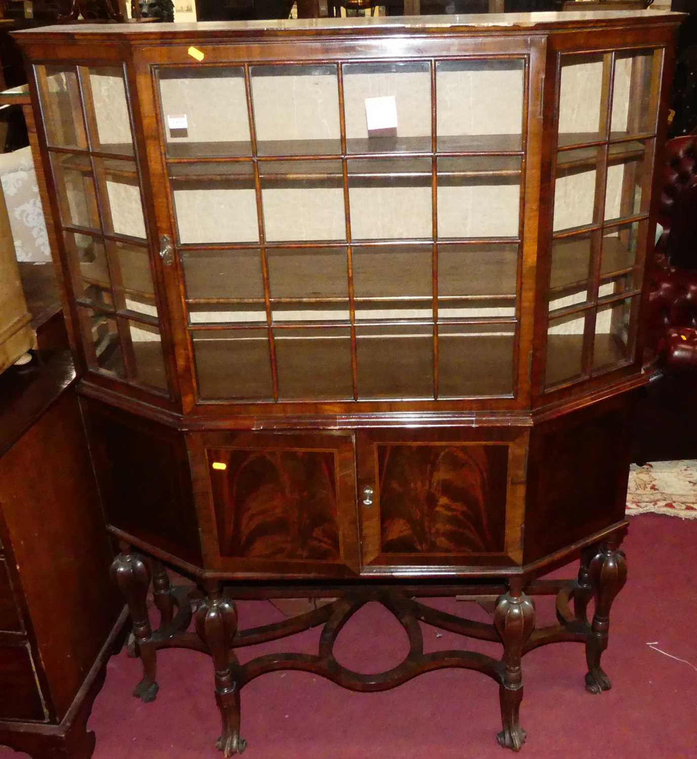 An early 20th century Dutch walnut single door glazed china display cabinet, having twin lower