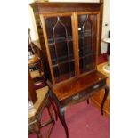 A circa 1900 mahogany double door glazed bookcase on stand, the stand with twin frieze drawers and