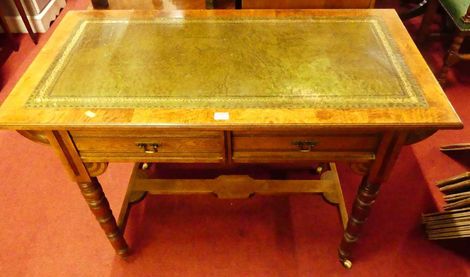 A Victorian Aesthetic Movement oak and burr oak two drawer writing table, having a gilt tooled green