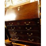 A George III mahogany slopefront writing bureau, having a fitted interior over four long graduated