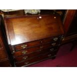 An early 19th century mahogany slope front four drawer writing bureau (some losses and damages to