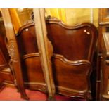 An early 20th century French carved walnut double lit-en-bateau, having a shell crested top rail