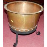 An early 20th century riveted copper circular log bucket, on wrought iron stand, overall h.46cm,