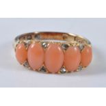 A yellow metal coral half hoop eternity ring, comprising five oval pink coral cabochons with eight