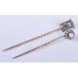 Two yellow and white metal diamond set stick pins, one comprising a royal monogram surmounted by a