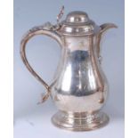 An early George III silver wine or beer jug, having a hinged domed cover, S-scroll handle, and