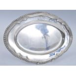 A George II heavy silver dish, of shaped oval form with a stepped gadrooned border, engraved with