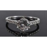 A white metal diamond solitaire ring, comprising a centre round brilliant cut diamond in a six-