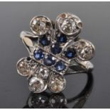 A white metal 'fleur de lys' sapphire and diamond cluster ring, featuring a centre section of