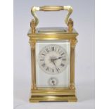 A circa 1900 lacquered brass carriage clock, having three-quarter turned pilasters flanking white