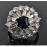 A white metal, sapphire and diamond bombe cluster ring, featuring a centre step cut sapphire
