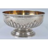 A late Victorian silver trophy bowl, of half-gadrooned circular form, bearing inscription '