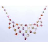 A yellow metal multi-stone fringe necklet, featuring oval faceted garnet, amethyst, peridot,