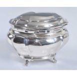 A George V silver sugar box, of lidded oval sarcophagus form standing on four scroll feet, maker