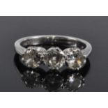 A white metal diamond three stone ring, featuring three graduated round brilliant cut diamonds in