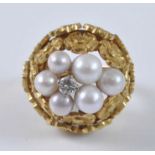 A yellow metal, pearl and diamond bombe ring, featuring a centre round brilliant cut diamond