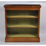 A walnut and figured walnut open bookshelf, having a cross and feather banded top above two