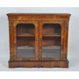 A Victorian figured walnut and gilt metal mounted pier cabinet, having twin glazed doors enclosing