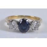 An 18ct yellow and white gold, sapphire and diamond three stone ring, featuring a centre oval