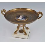 A late 19th century French gilt bronze twin handled comport, the circular dish with convex inset