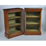 A pair of oak freestanding open bookshelves, each having a crossbanded top above twin adjustable