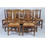 A set of eight George III joined oak dining chairs in the Hepplewhite style, each having pierced