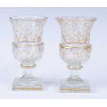 A pair of circa 1820 cut glass goblets, each having gilt decoration, the baluster form bowl above