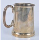 A George V silver tankard, having plain loop handle, stepped rim and clear glass base, initialled to