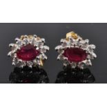 A pair of 18ct yellow and white gold, ruby and diamond oval cluster earrings, each featuring a