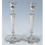 A pair of George III silver loaded candlesticks in the neo-classical taste, having chased reeded and