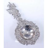 A late 19th century continental silver sifting spoon, the terminal elaborately cast with a three-