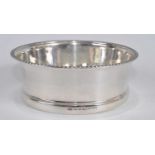 A George V silver and glass bottle coaster, the plain silver rim having a gadrooned rim, maker