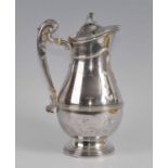 An Edwardian silver hot milk pot, of banded baluster form with reeded and scrolling handle and