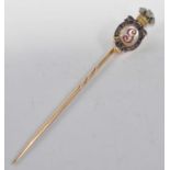 A yellow metal George Prince of Wales stick pin, featuring an oval reverse crystal with initial G,