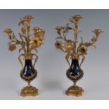 A pair of mid-19th century gilt metal and porcelain four-light candelabra, each naturalistically