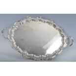 An Edwardian silver twin handled drinks tray, having raised shell and piecrust rim, 82oz, maker