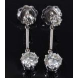 A pair of white metal diamond drop earrings, each comprising two round brilliant cut diamonds in rex