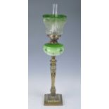 A Victorian brass oil lamp, having an acid etched green tinted glass shade above a green tinted milk