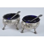 A pair of George III silver table salts, of oval form with gadrooned rims and repousse decoration,