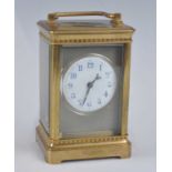 A late 19th century French lacquered brass carriage clock, having a white enamel Arabic dial,