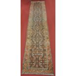 A Persian woollen hall runner, the blue ground decorated with stylised flowers and foliage within