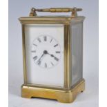 A circa 1900 brass carriage clock, having unsigned white enamel Roman dial, visible platform