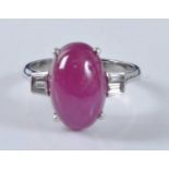 A white metal, ruby and diamond ring, comprising an oval cabochon cut ruby in a four claw setting